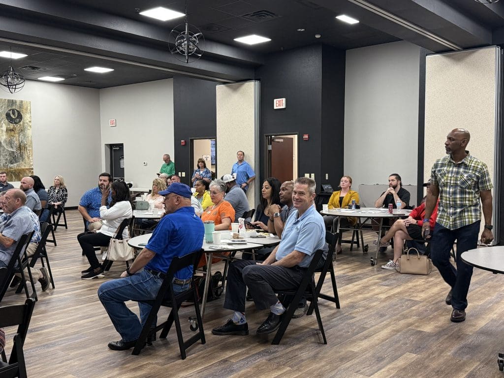 Large group of people seated at tables looking ahead of them